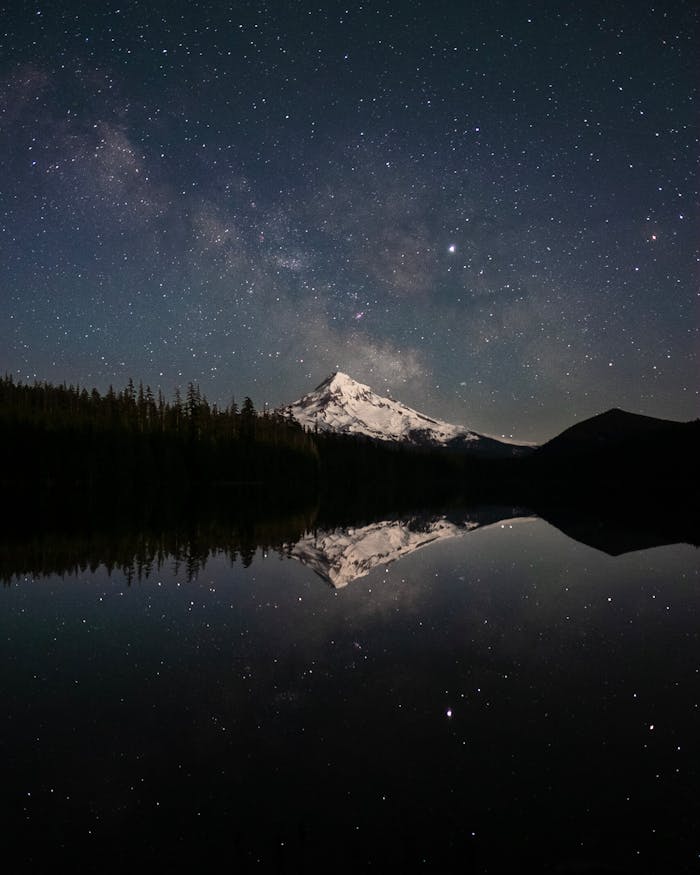 services-01 Snow-capped Mount Hood reflected in a serene lake under a starry sky, Oregon.